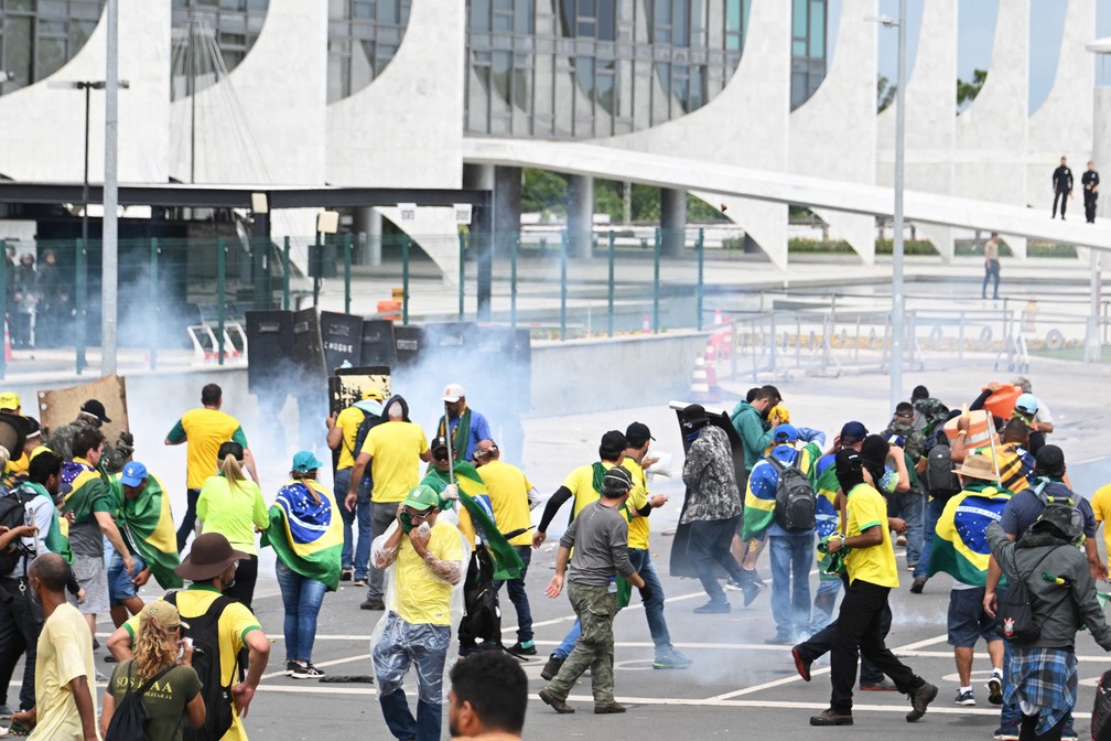 Criminosos são repreendidos pela polícia diante do Palácio do Planalto em Brasília — Foto: Evaristo Sá/AFP