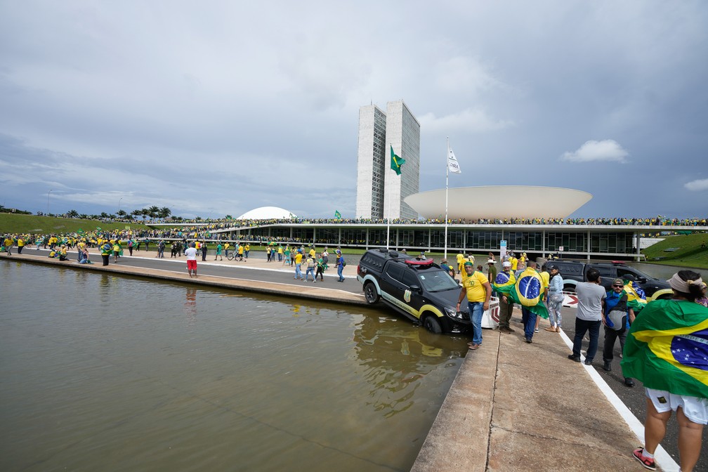 Viatura da Polícia Legislativa Federal foi empurrado por vândalos para dentro de um espelho d'água diante do Congresso Nacional — Foto: Eraldo Peres/AP